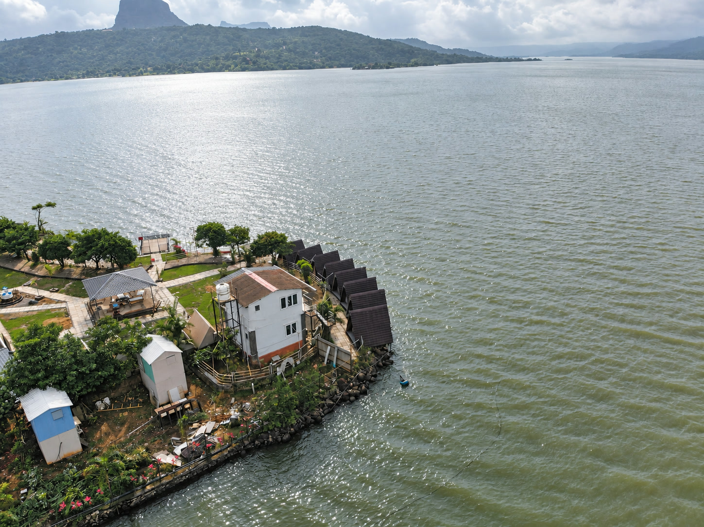 High aerial view of NightVibe lakeside triangle cabins and Pawna Lake.