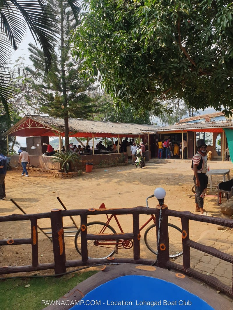 Outdoor view of Lohagad Boat Club with visitors and seating areas near Pawna Lake.