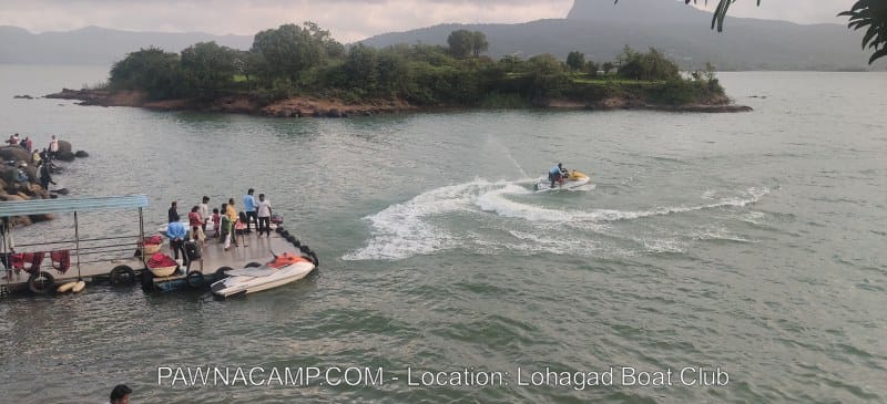 Jet ski on Pawna Lake with people gathered at the Lohagad Boat Club dock.