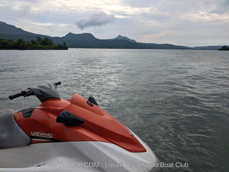 Orange and white jet ski positioned on the water at Lohagad Boat Club near Pawna Lake.